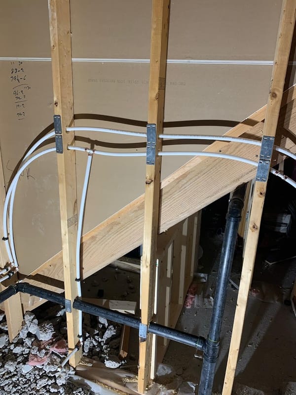 Renovation plumbing routed under a staircase